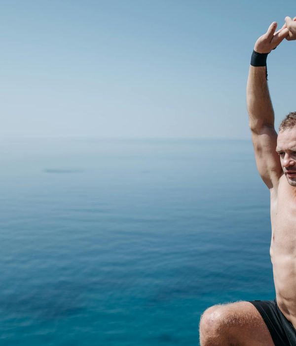 Man stretching outdoors with a serene natural background.